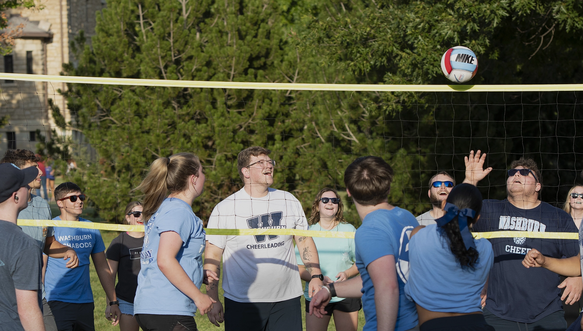 Washburn students laugh while playing volleyball.