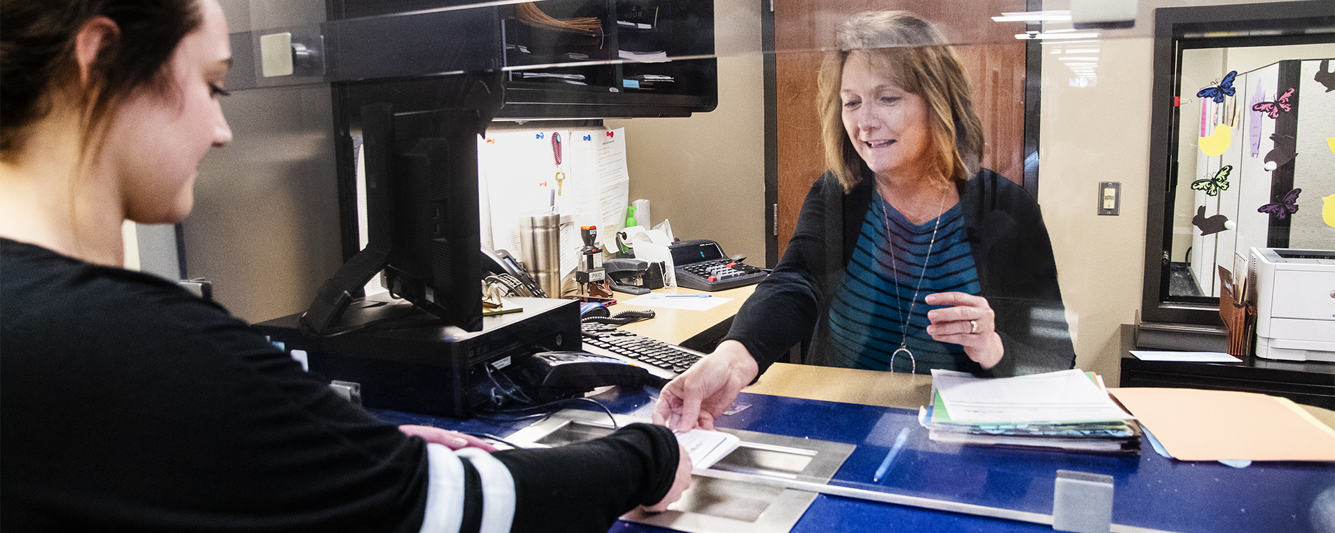 A Washburn student pays her bill at the Business Office window in Morgan Hall.