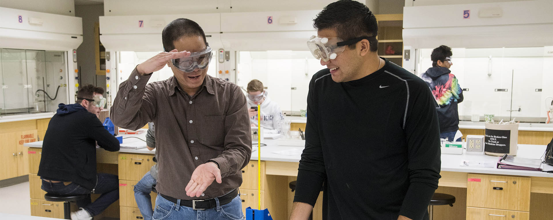 a chemistry professor explains something in a lab to a student