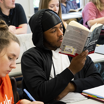 A student reads a book while in class.