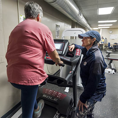 WU Moves client on treadmill, trainer looking on.