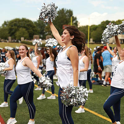 Dancing Blue jumps and cheers with other blues on sidelines