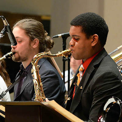 two students playing saxophone in class