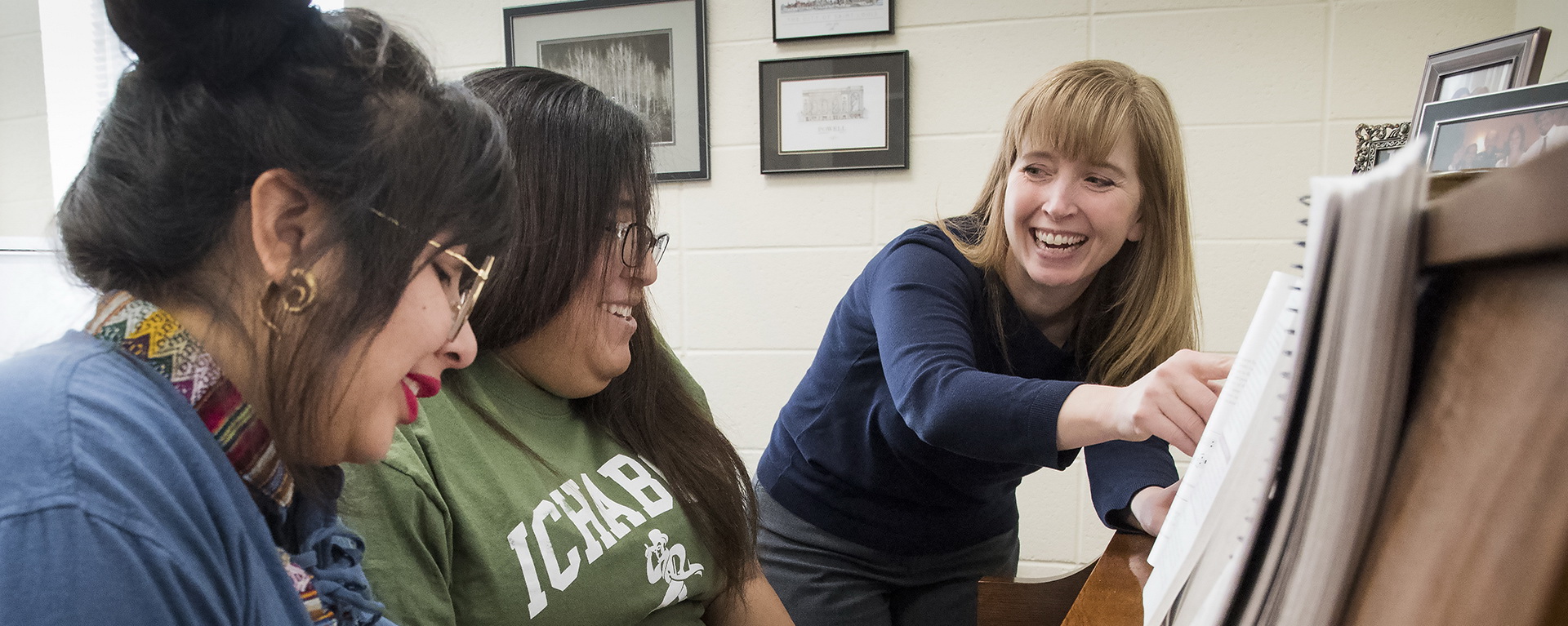 Music professor and two students with a piano