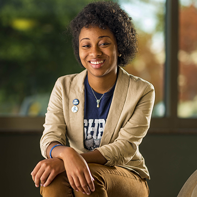 A woman smiles while wearing a blazer over her Washburn shirt.