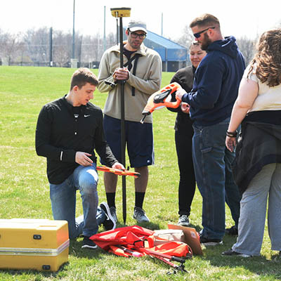 Students use an instrument while working outdoors