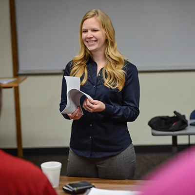 instructor smiling holding papers