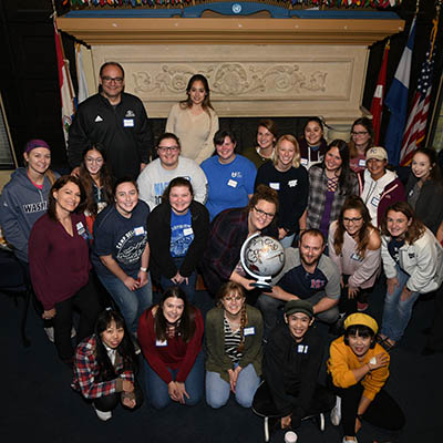 International and domestic students pose for a photo with a globe