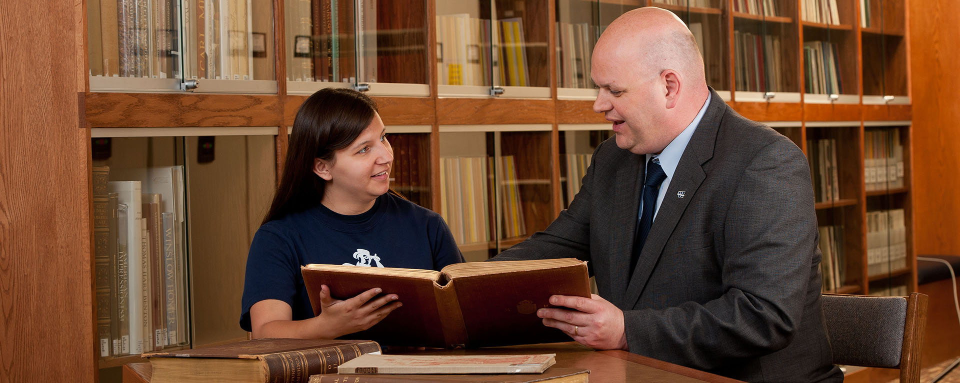 Dr. Bearman reading a book with a Student 