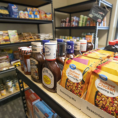 A shelf of bbq sauce, chicken seasoning and other items.