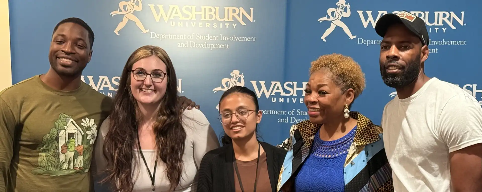CAB members smile in front of Washburn logo backdrop