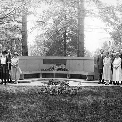 People pose for a photo around the Larrick Memorial bench when it was dedicated.