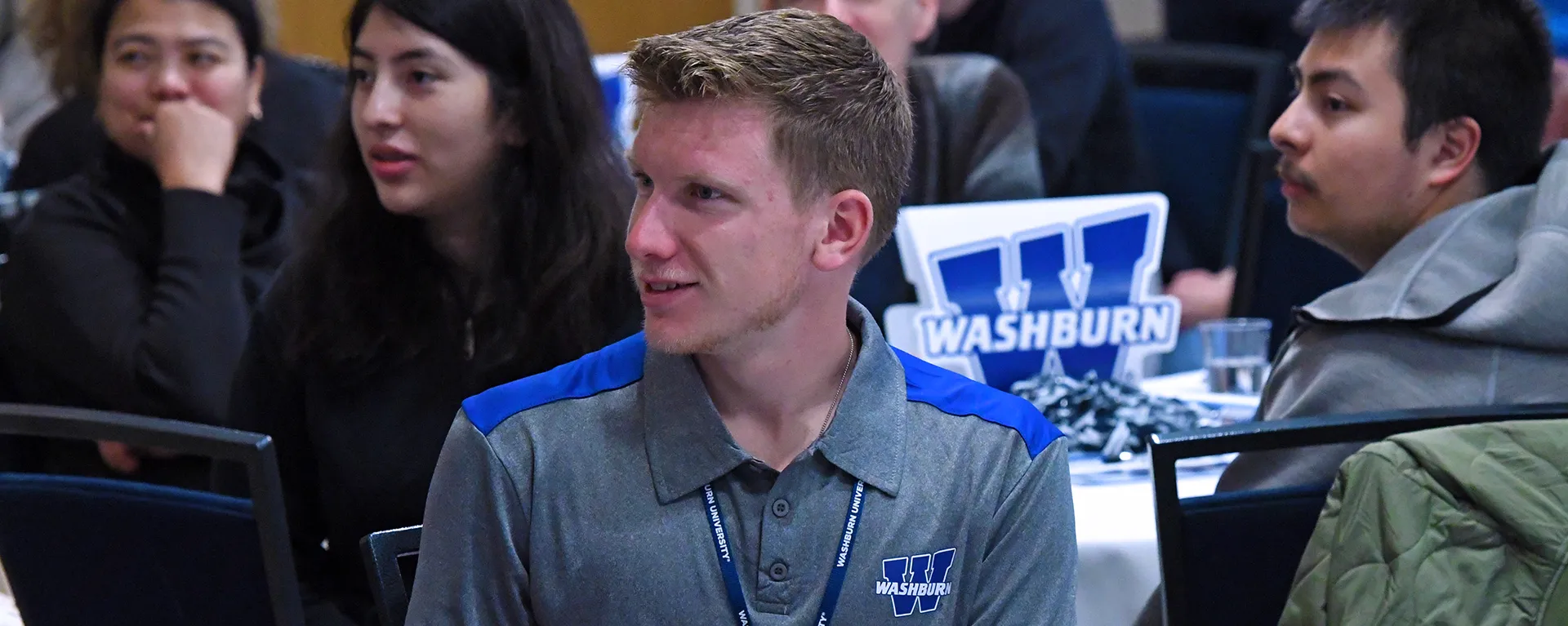 A high school listens during an enrollment event.