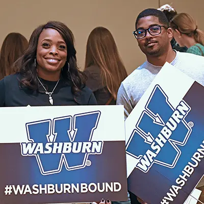 A student and parent pose with #WashburnBound signs.