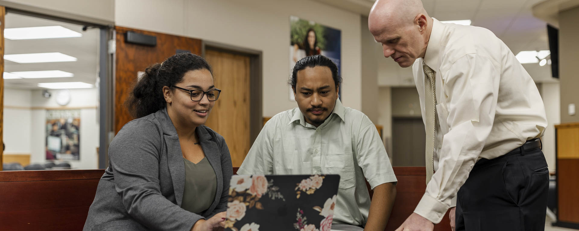 A business professor helps two students study.