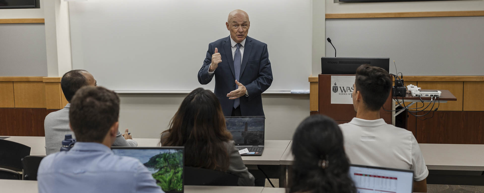 A business professor speaks before a class.