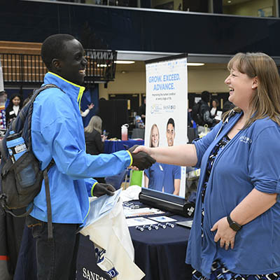 A student shakes hands with a prospective employer.