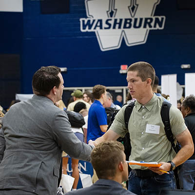 student shaking hands with employer at career fair