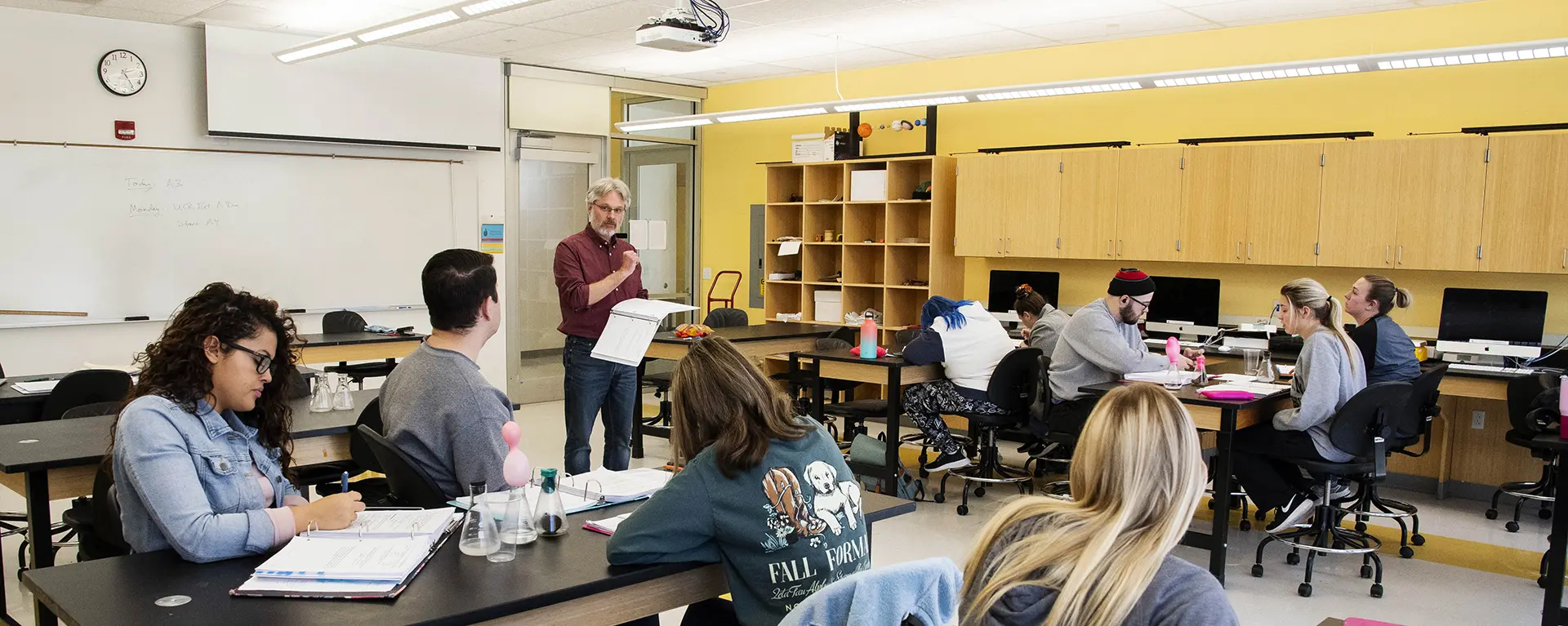 students and professor in physics lab