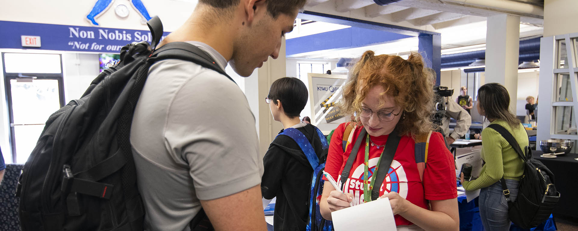 A journalism student interviews a couple of students.