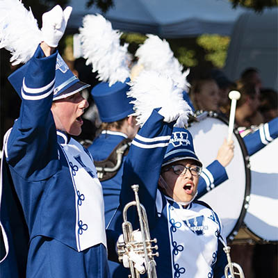 two marching band members outdoors performing