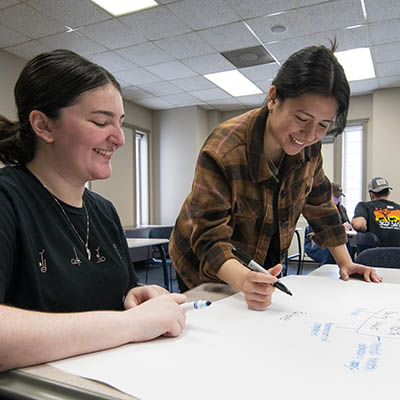 student with instructor in class working smiling