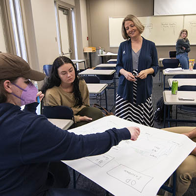 Sociology students and a professor discuss an in class project