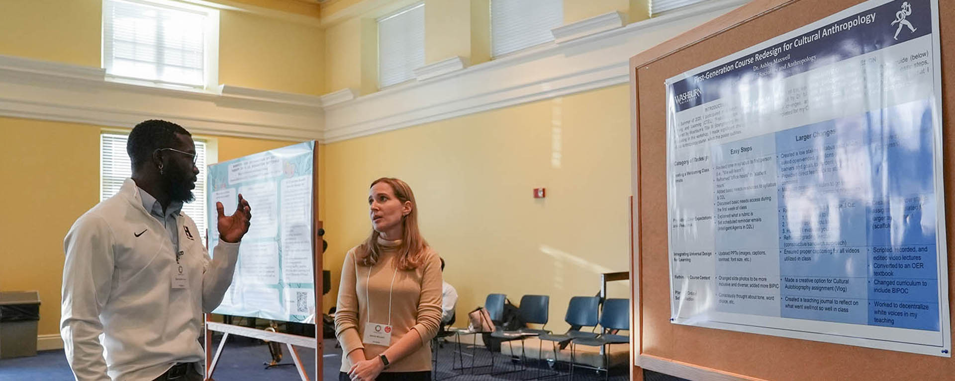 two people talking in front of information board at Tilford Conference