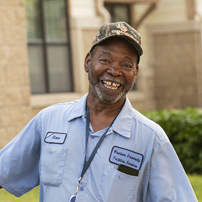 A custodial employee smiles.