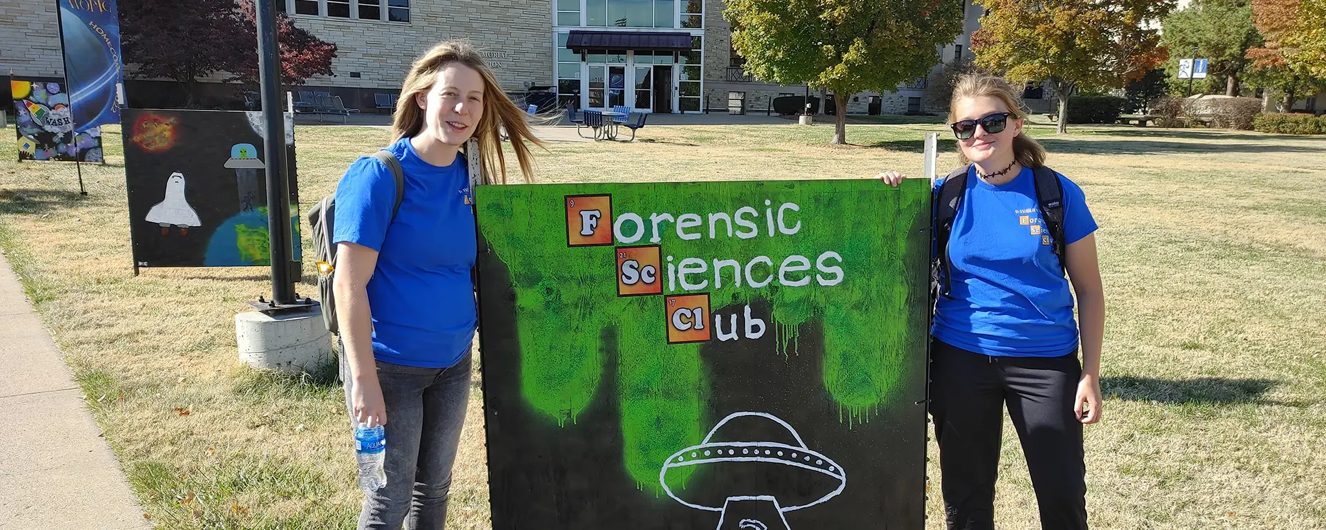 Forensic Science club members pose with their sign for homecoming.