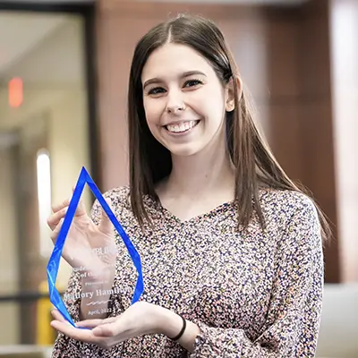 A student employee award winner poses with her award.