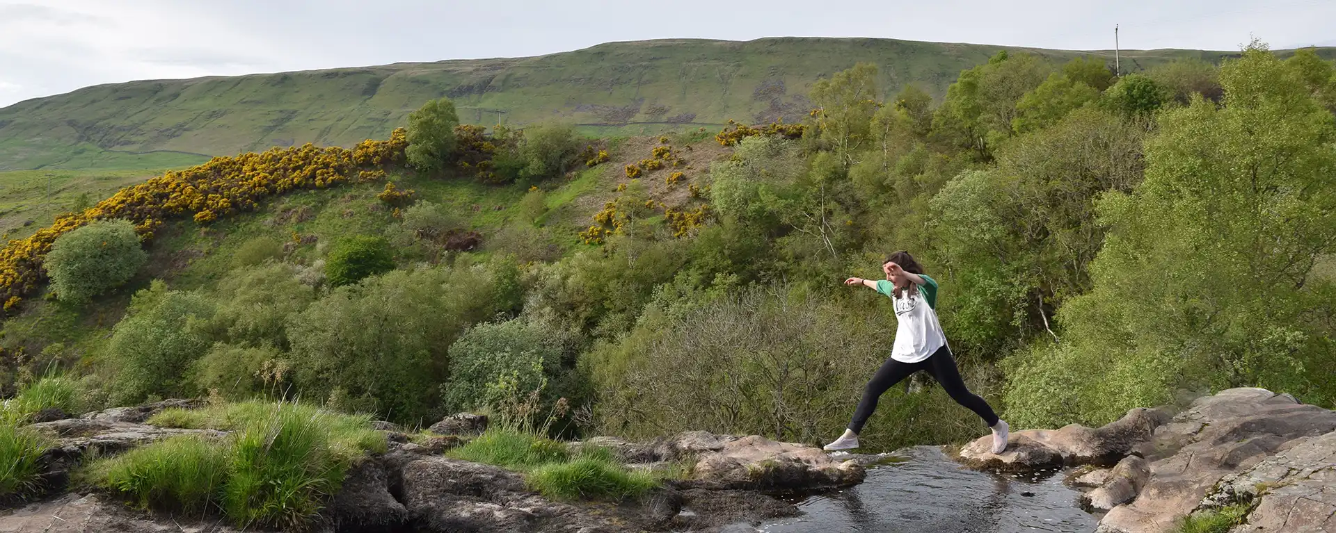 students crossing a creek in Scotland