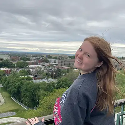 Katt Higgins posing on a patio overlooking the city
