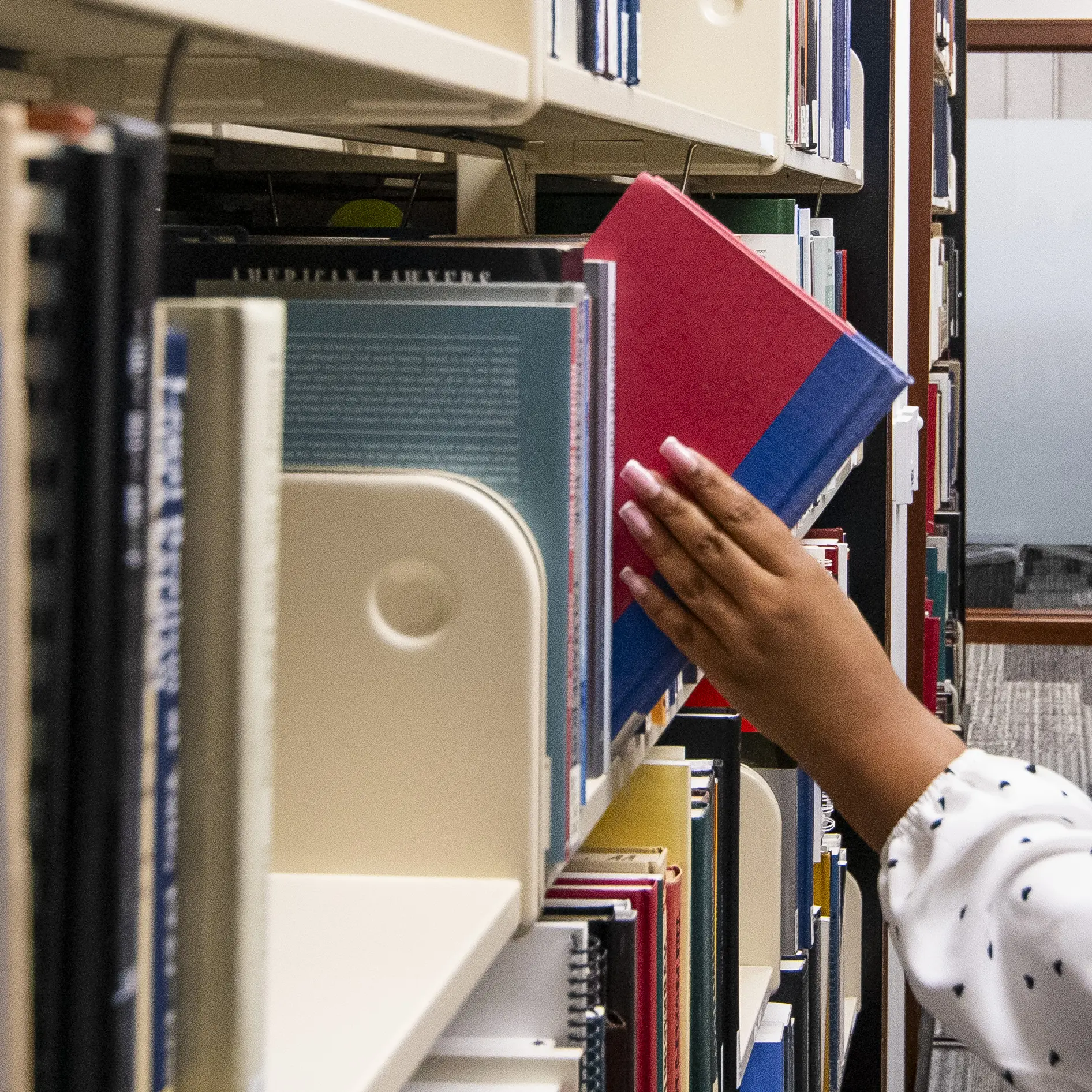 A user grabs a book off the shelf.