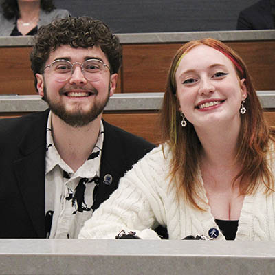 two students sitting in class smiling