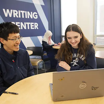 Two students work on an essay in the writing center.