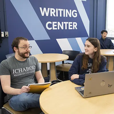 An English tutor helps a student with their writing assignment.