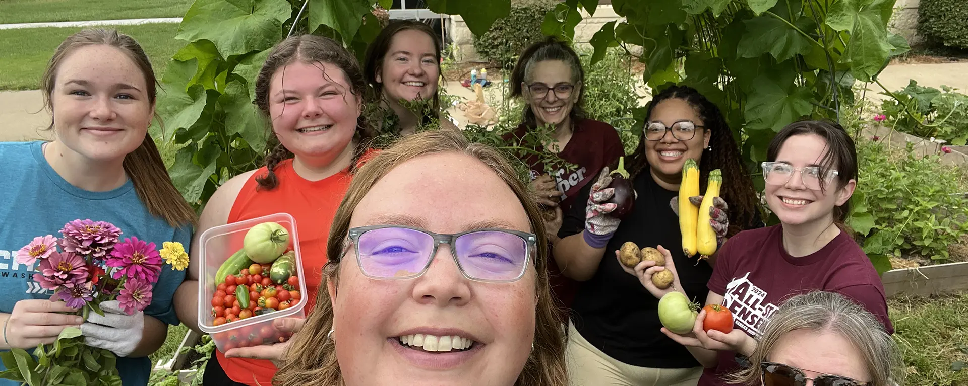 Students, faculty and staff with harvest from the community garden.