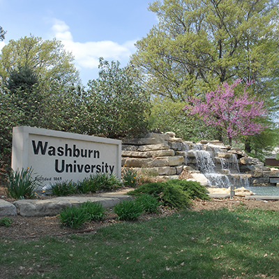 Washburn University waterfall sign with flowering trees